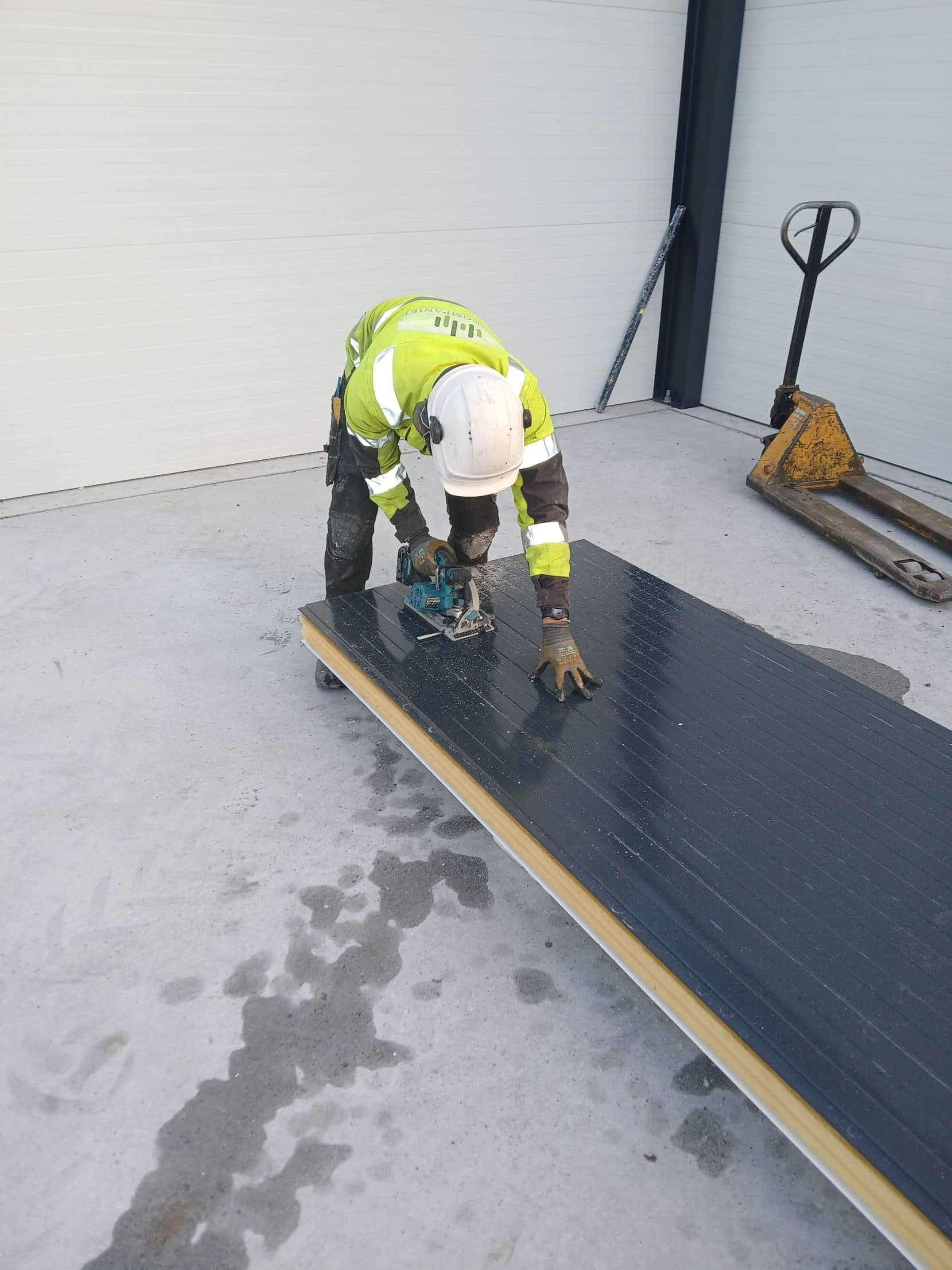 Erector cutting a sandwich panel to size on site