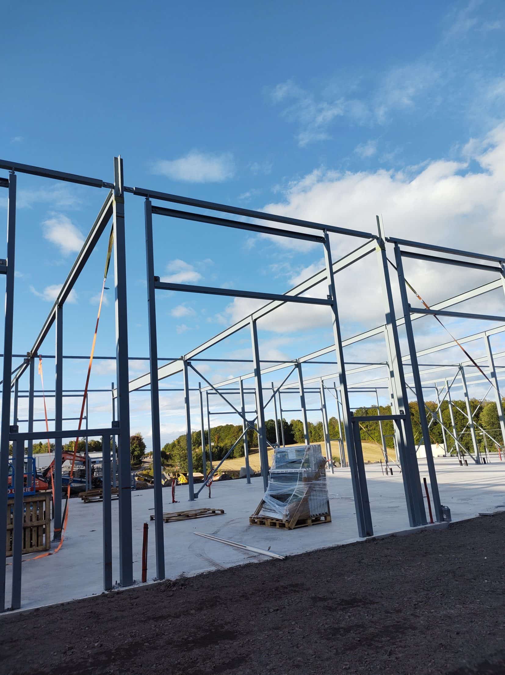 Steel frame being erected on the concrete slab, with columns and beams in place