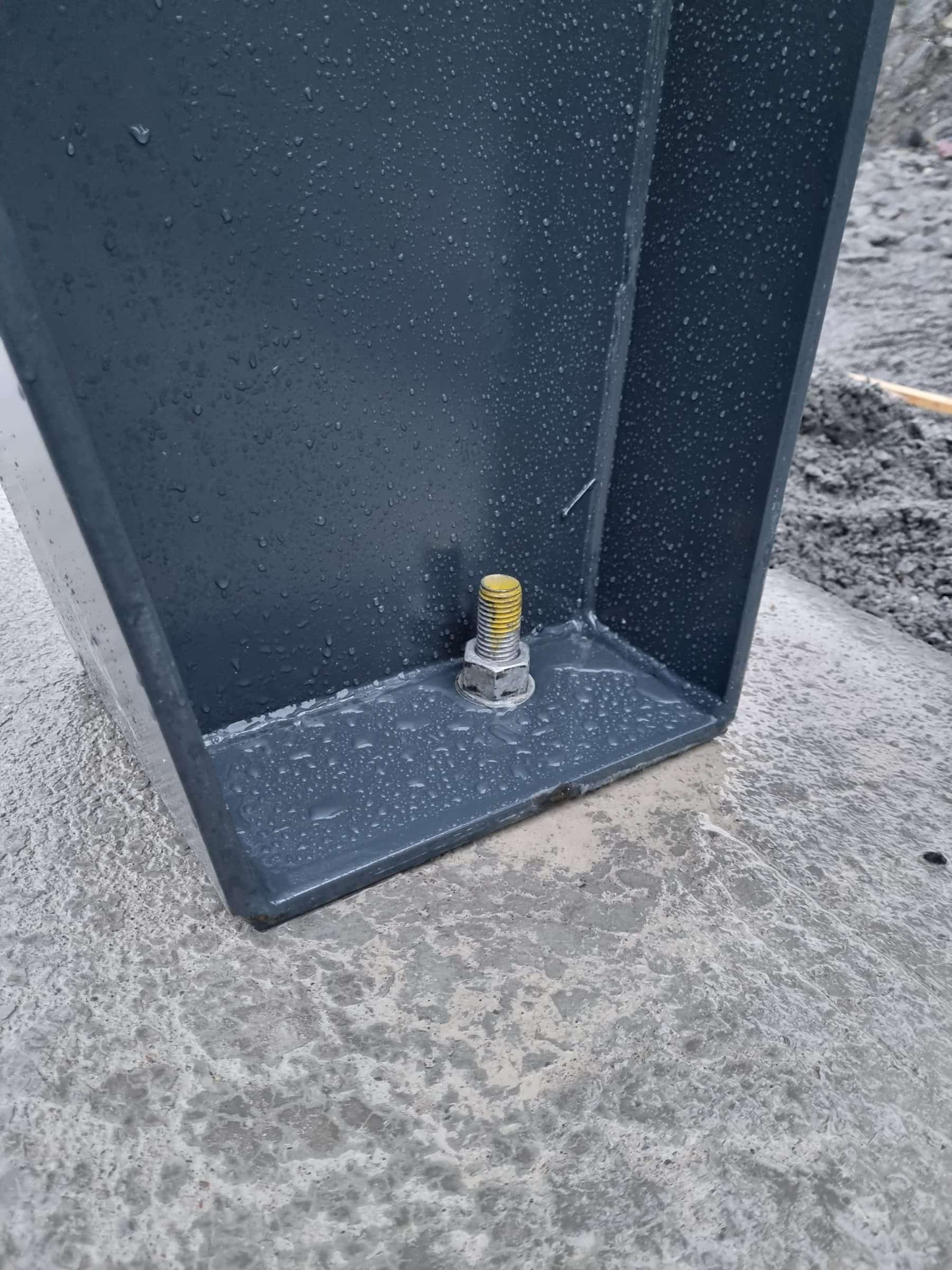 Detail of a steel column base plate with its anchor bolt in the slab